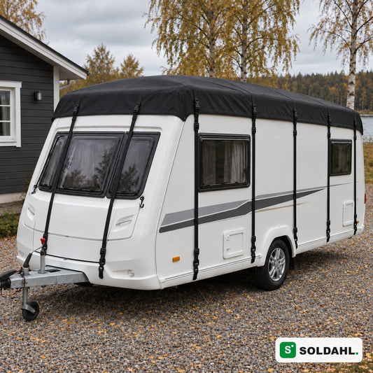 Svart taktrekk montert på hvit campingvogn i en grusinnkjørsel