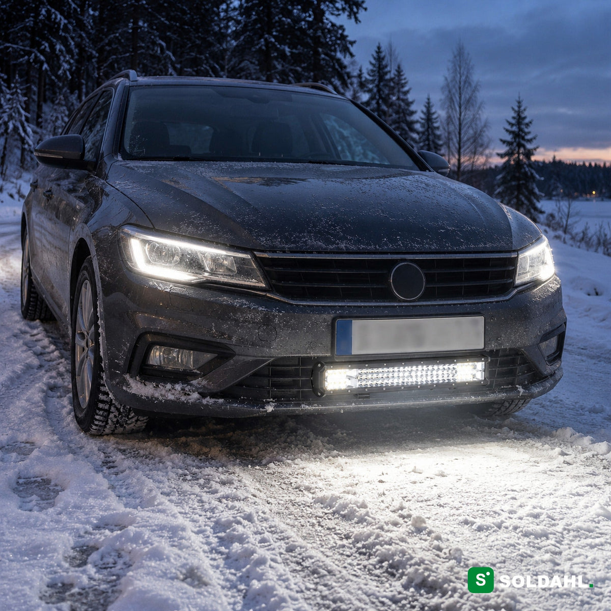 LED-lysbar montert under støtfangeren på en bil på en snødekt vei i skumringen