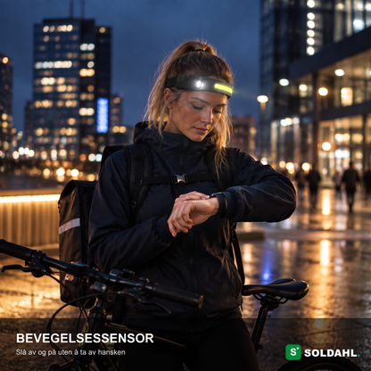 Syklist i byen om kvelden med Vidsyn, bevegelsessensoren slår på lyset uten at hansken må av