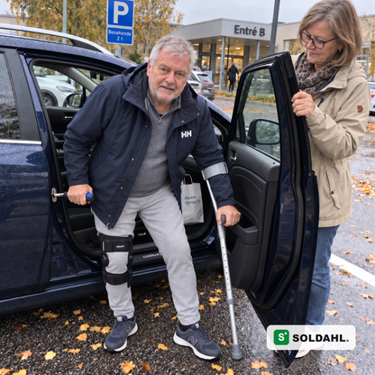 Mann med kneortose etter operasjon reiser seg ut av bilen med Stødro hektet i låsebøylen