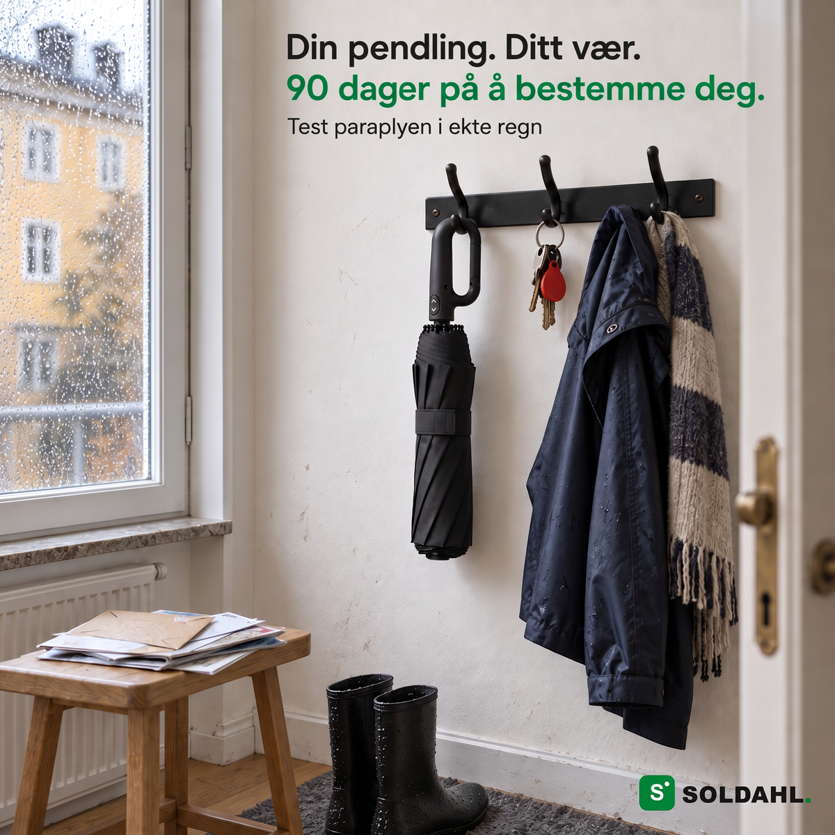 Sammenslått Stormparaply henger i ringhåndtaket på en knagg i gangen