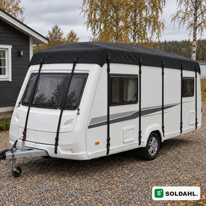 Svart taktrekk montert på hvit campingvogn i en grusinnkjørsel